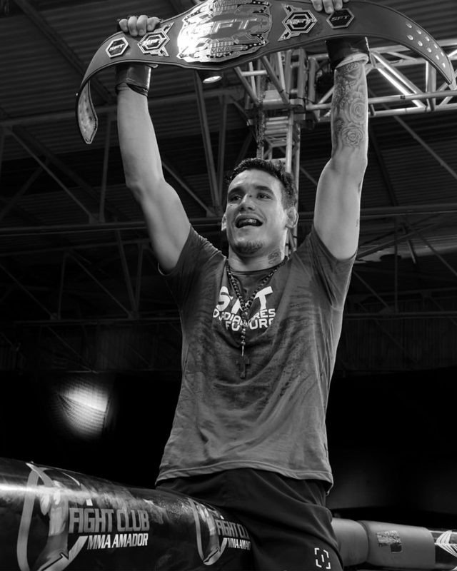 Atleta erguendo o cinturão de campeão